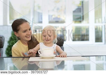 Mom With Child In Cafe Drinks Coffee. Vacation With Child.