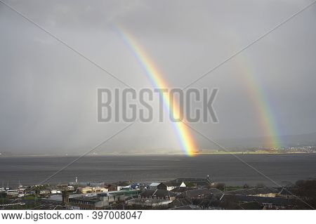 Bright Rainbow High In Sky Over The Sea During Dark Storm