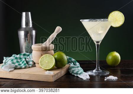 Typical Mexican Margarita Cocktail With Limes And Cocktail Shaker On  Black And Green Background On 