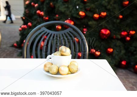 Shopping Village Cafe. Coffee Cup With Golden Christmas Balls Inside And Around. Coffee Pair On Whit