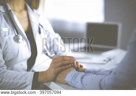 Unknown Woman-doctor Is Holding Her Patients Hands, Discussing Current Health Examination, While The
