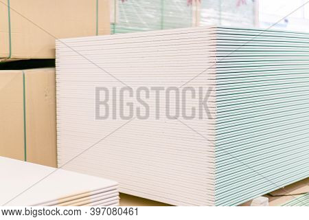 Pallet With Drywall Sheets Plasterboard In The Building Warehouse Store. Stacking Of White Gypsum Pa