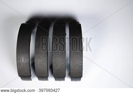 New Set Of Four Brake Pads For Drum Brakes On A Gray Background