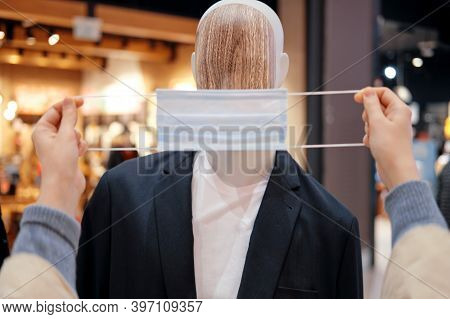 Medical Mask Is Put On A Mannequin With Clothes, Man In Store. Help With The Coronavirus Pandemic