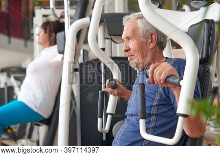 Older Man Doing Strength Exercise At Gym. Mature Man Working Out At Fitness Club. Resistance Exercis
