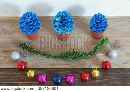 Christmas Decorations. Colorful Christmas Balls And Blue Pine Cones In Flower Pots On Rustic Table. 