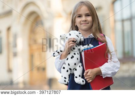 Learn And Play Preschool. Small Kid Hold Toy Dog And Books. Early Childhood Education. Back To Schoo