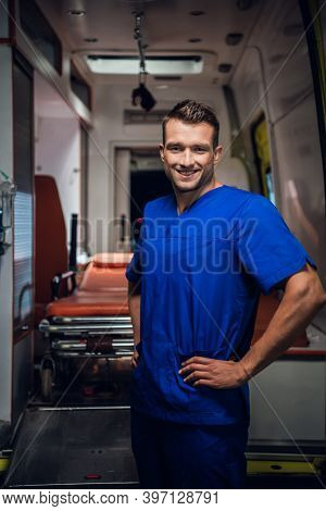 Happy Corpsman Standing And Looking At The Camera And Smiling, Ambulance Car In The Background.