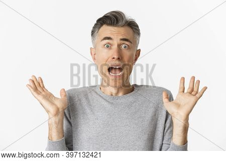 Close-up Of Scared Middle-aged Man, Looking Startled, Jumping And Screaming Frightened, Standing Amb