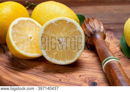 Fresh Ripe Yellow Italian Lemons And Wooden Juice Squeezer, New Harvest