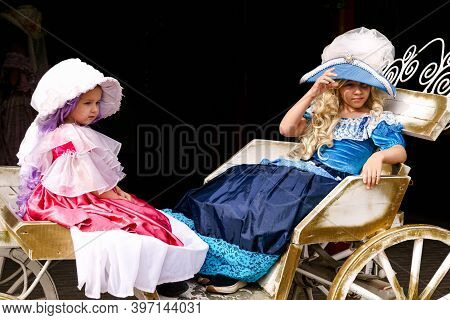 Two Sisters In A Carriage, Dressed In Luxurious Vintage Dresses And Hats.puppet Museum, July 2020 In