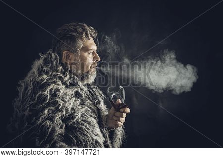 Solid Bearded Man In A Fur Mantle Smoking Pipe