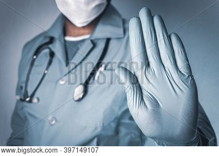 Hand Stop Sign. Doctor Wearing Medical Mask And Gloves. Coronavirus, Covid-19 Concept And Background