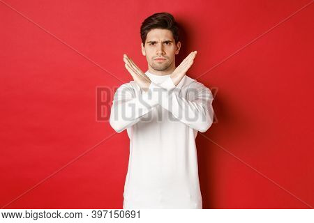 Image Of Serious And Angry Man In White Sweater, Express Storng Disapproval, Showing Cross Sign To S
