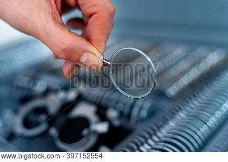 Hand Changes Lenses Of Trial Frame Phoropter. Lenses From Set Of Corrective Frame. Eye Test Glasses 