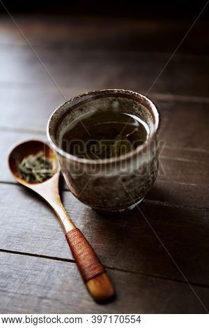 Green Tea (sencha) In A Traditional, Japanese Tea Cup And Sencha Leaves On A Wooden Tea Spoon. Dark 