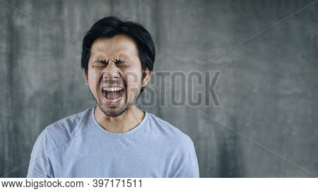 Young Asien Man Suffering From Pain On Against A Gray Background