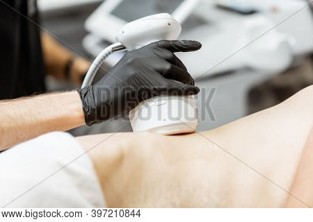 Man During An Ultrasound Liposuction Procedure At Luxury Spa Salon. Doctor Working On Waist Side Are