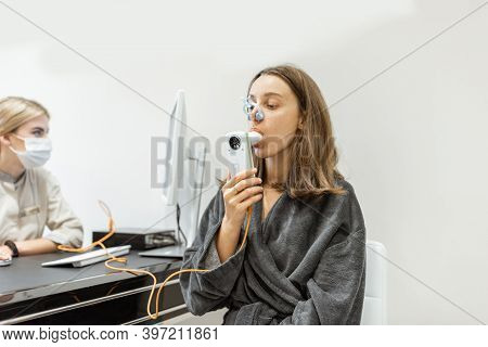Young Woman With Doctor During A Spirography Test, Measuring Breathing Movements With Spirometer At 