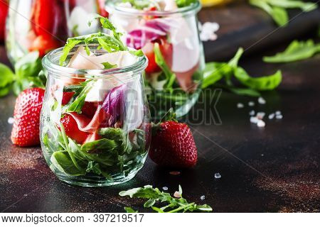Fresh Salad With Spicy Arugula, Goat Cheese, Strawberry And Prosciutto Or Ham In Modern Glass Jars O