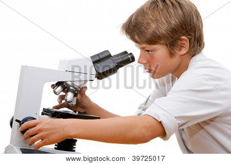 Joven estudiante mirando a través del microscopio.