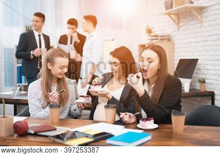 Two Young Girls Are Laughing At Work Annoying Boss. Two Women Are Standing In The Office With Papers