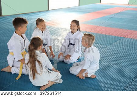 Group Of Children In Kimono Sitting On Tatami After Karate Practice