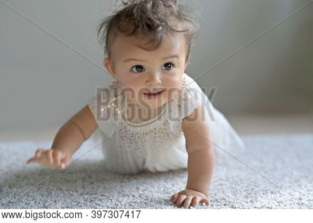 Cute 8-month-old baby girl crowling on all four
