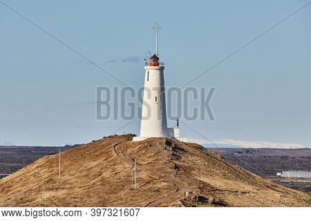 Reykjanes Lighthouse in Iceland with Gunnuhver geotermal area in the background