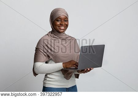 Online Education. Portrait Of Smiling Black Muslim Lady In Headscarf Holding Laptop, Enjoying Distan