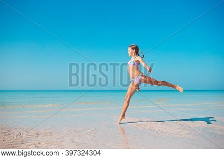 Adorable Active Little Girl At Beach During Summer Vacation