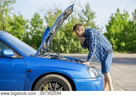 The Sad Disappointed Man Standing Near The Car With Opened Hood, Fix Some Problems With Engine
