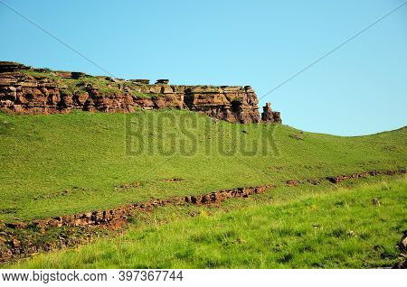 Remains Of An Ancient Red Stone Wall Running Along The Top Of The Hill.