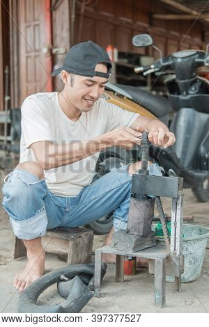 Tire Patcher Holds The Press Before Patching The Leaky Inner Tube