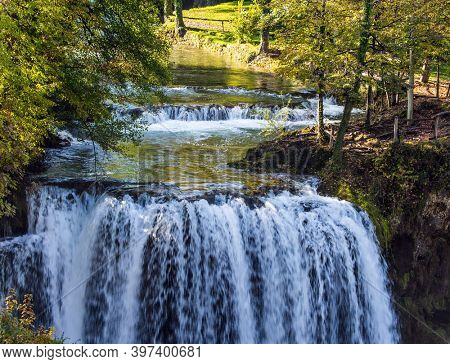 The small Croatian town of Slunj. The concept of ecological, active and photo tourism. Magnificent cascade of waterfalls on the Korana River. The forest surround the city and the river