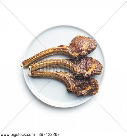 Grilled lamb chops on plate isolated on white background. Top view.