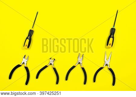 Tools On A Yellow Background With Space For Text. Screwdrivers, Pliers, Biters, Rounds, Tongs A Bann