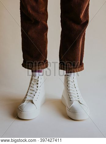 White high top sneakers on corduroy pants model
