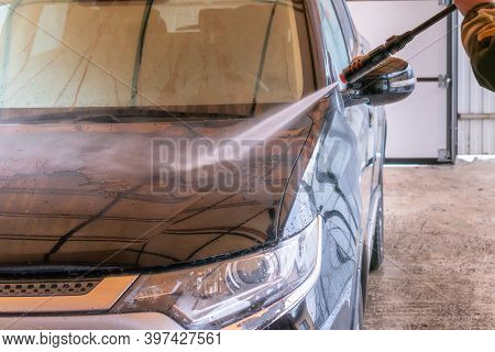 Car Wash With Karcher. The Man Washes The Black Car.