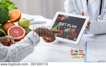 Dietologist Doctor Holding Digital Tablet With Opened Diet Plan Application, Female Patient Choosing