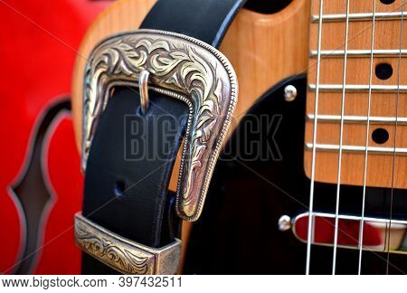 Electric Guitars And Leather Strap With Silver Buckle Close-up.