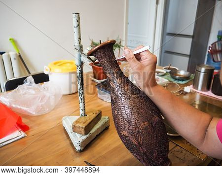 Woman Gluing Tiny Shaped Cloisonne Wires To A Copper Vase Creating A Intricately Constructed Pattern