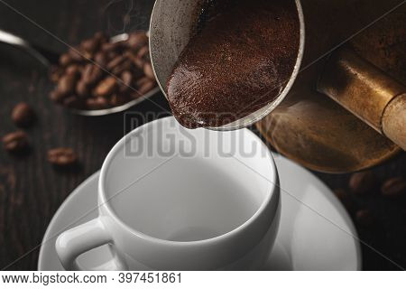 A Cup Of Coffee And Coffee Beans On The Table. Black Background