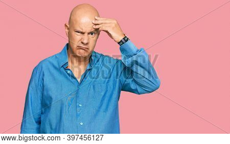 Middle age bald man wearing casual clothes worried and stressed about a problem with hand on forehead, nervous and anxious for crisis 