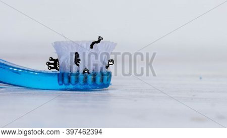An Old Blue Toothbrush With Bristles, Black Worms Come Out Of The Bristles Of A Bad Toothbrush.