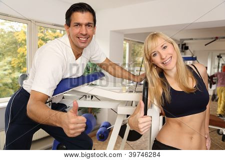 attraktive blonde Frau und ihr Trainer in einem Fitnessstudio