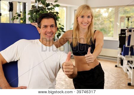 attraktive blonde Frau und ihr Trainer in einem Fitnessstudio