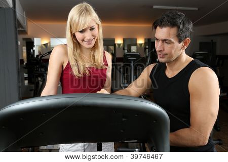 Attraktive Blonde Frau und ihr Trainer In einem Fitnessstudio