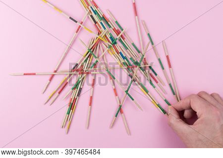 Top View Of Hand Of Person Trying To Pick Up Mikado Stick, Game Of Skill And Parlour Game Concept
