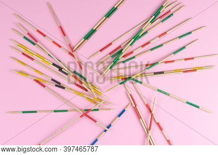 Directly Above View Of Jumble Of Wooden Mikado Pick-up Sticks On Pink Background